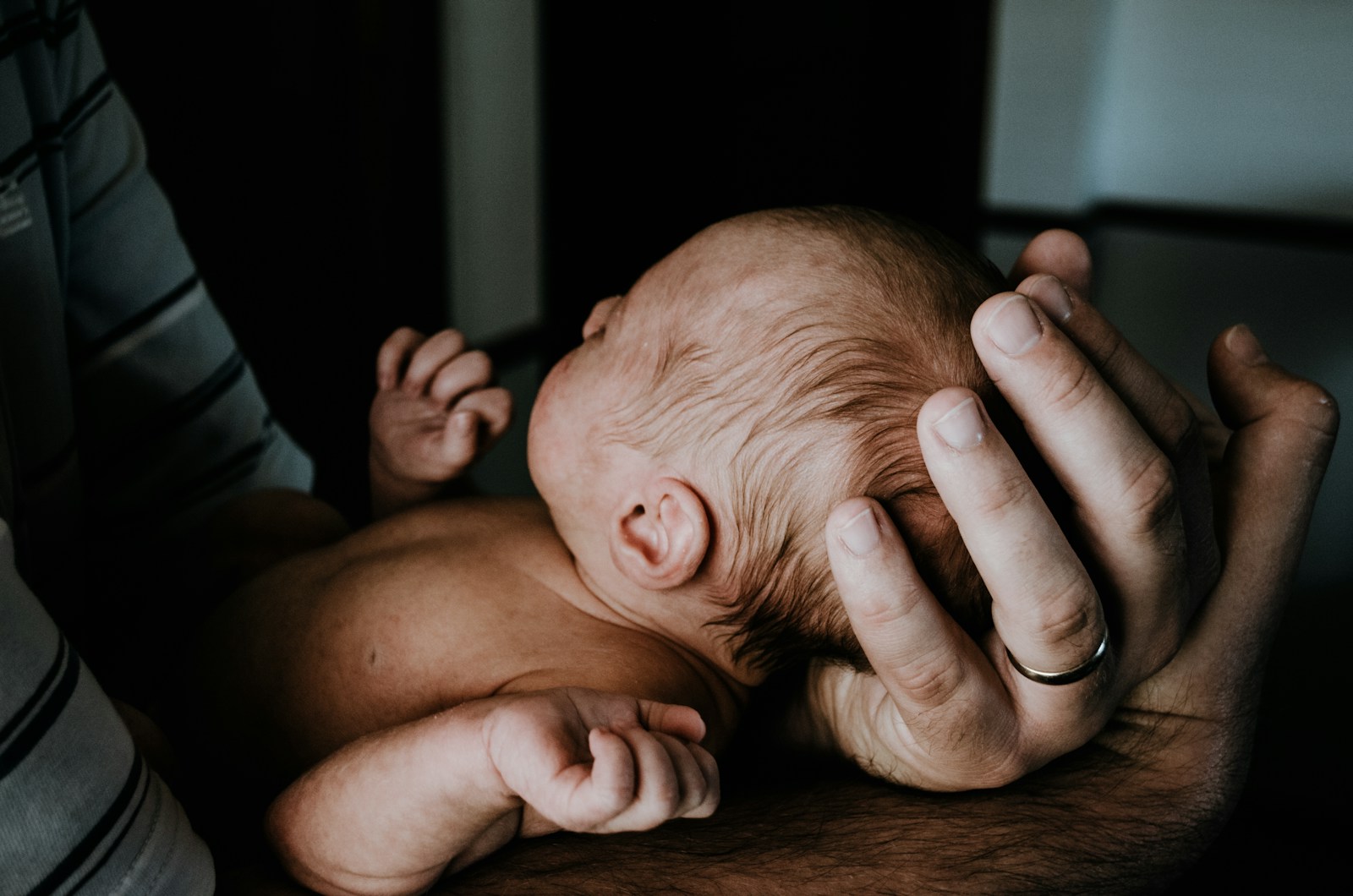a man holding a baby in his arms. Accessing support for anxiety and depression for fathers experiencing postpartum or perinatal depression is the best way to address common mental health challenges for new fathers